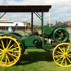 Green 'Sunshine' tractor with yellow painted steel wheels on display at Scienceworks