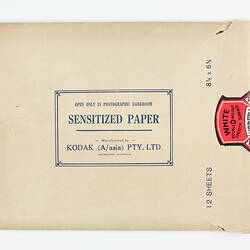 Brown paper packet with red product sticker.