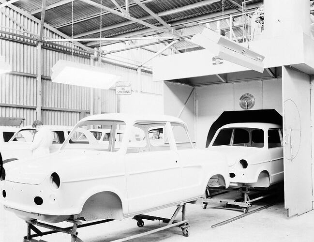 Monochrome photograph of a vehicle manufacturing plant.