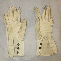 Pair of cream gloves, back side.