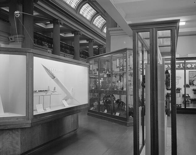 Museum interior with cabinets containing space and technology displays. Space shuttles, gears and typewriters.