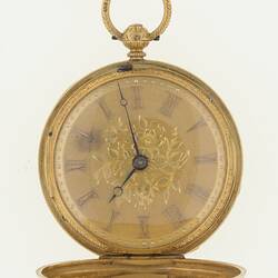 Ladies gold pocket watch, gold case. Roman numerals, black hands, ring at top.