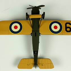Yellow underside of model airplane. Circle pattern on each wing.