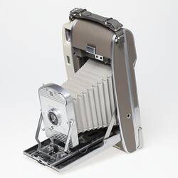 Off-white fold out camera, taupe cover, metal trim. White bellows.