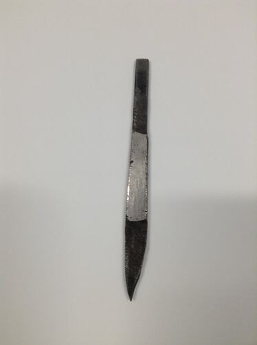 Long metal knife-like tool used for engraving jewellery.
