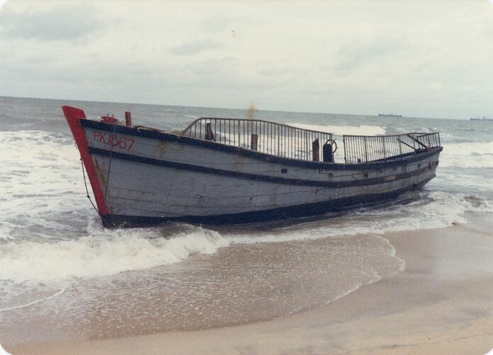 Fishing boat aground on beach.