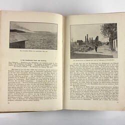 Inside pages of book showing photos of battle and ruined buildings.