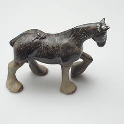 Fire affected brown and cream ceramic horse figurine.