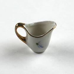 Tiny milk jug, handle left side.