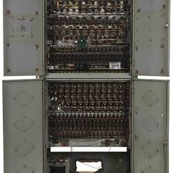 Metal cabinet with four open doors. Contains circuit boards and wires.