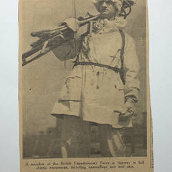 Back of off white newspaper cutting showing man with skis.