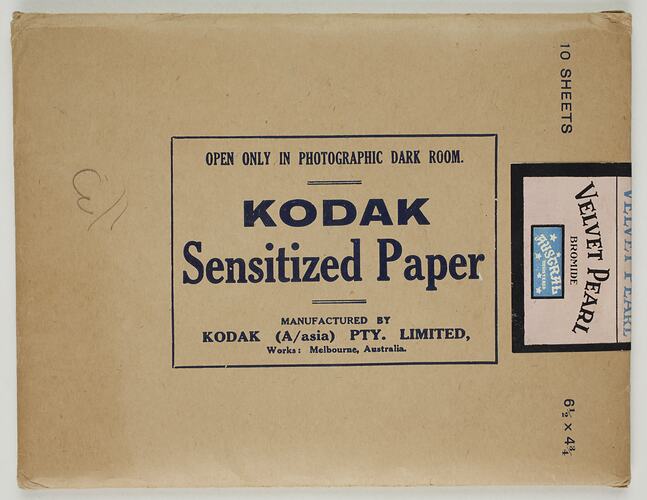 Flat sealed rectangular paper envelope with dark blue inscription. Pink sticker secures the flap.