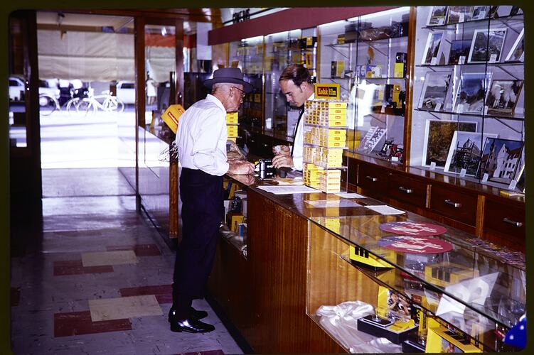 Two men at a retail counter.