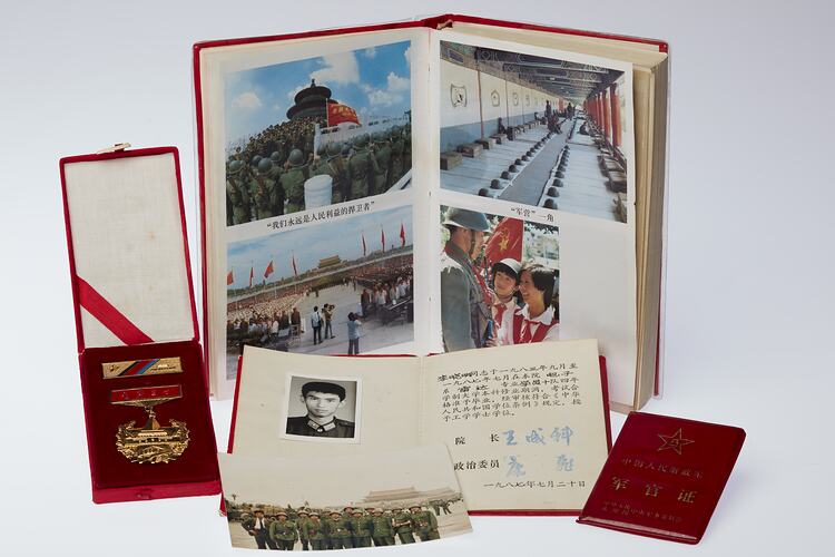 Group of items. Gold medal and bar in red velvet case, book with photos, two smaller books and loose photo.