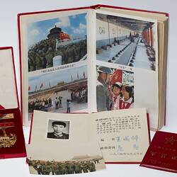 Group of items. Gold medal and bar in red velvet case, book with photos, two smaller books and loose photo.