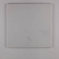 Plain back of a white exhibition label.