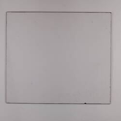 Plain back of a white exhibition label.