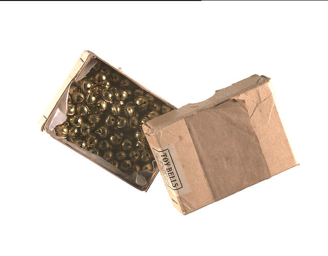 Cardboard box with lid off showing brass bells inside.