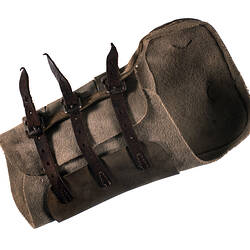 Brown leather shin pad with three straps.