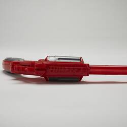Red and grey plastic toy revolver, top view.