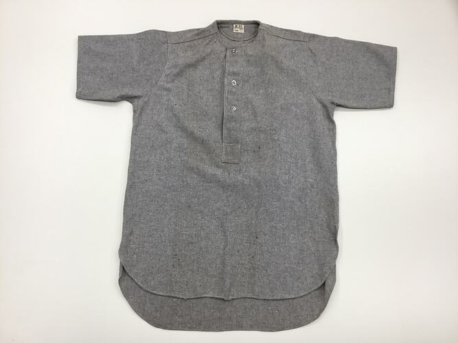 Grey flannel shirt. Short sleeved, three buttons at neck.