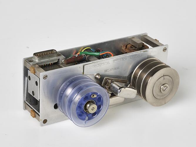 Small metal box two wired reels on top. One reel is blue plastic the other metal.