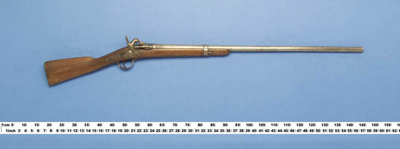 Single barrelled shotgun. Wooden half stock secured to barrel by a single band.