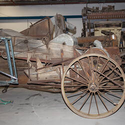 Weathered, worn self-propelled harvester with standard front, pick-up front, rice front and pea front.