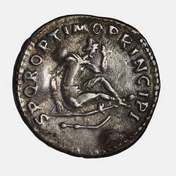 Round coin with figure seated on shield facing right. Curved sword below. Text above.