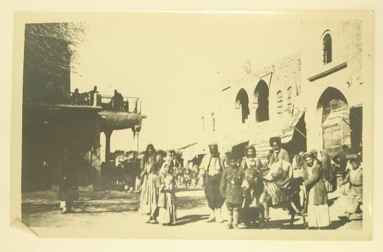 Villagers posing in street with donkey.