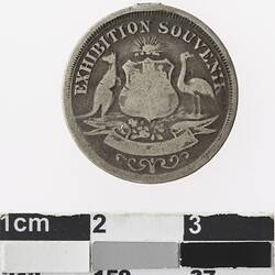 Round silver coloured medal with Australian coat of arms and text above.
