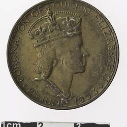 Round medal with profile of a crowned woman, text surrounding.