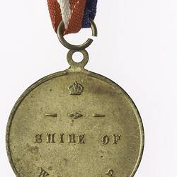Round medal with text and with red, white and blue ribbon attached.