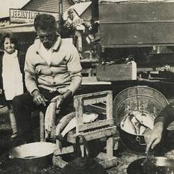 Digital Photograph - Holden Brothers Circus, Man Cleaning Fish with Girl Next to Him, circa 1934