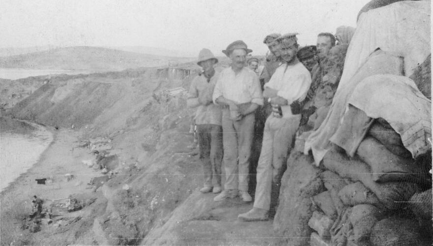 Extreme right of Anzac showing soldiers outside dug out and supplies on the beach.