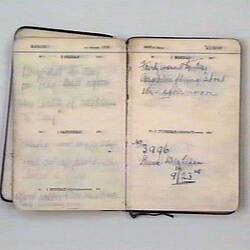 Open book with off-white pages, handwritten text on both pages.