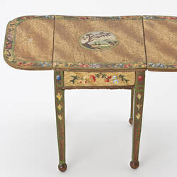 Drop leaf table with painted floral decoration.