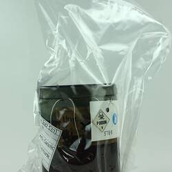A labelled brown jar in a plastic bag.