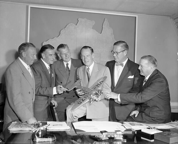 Ansett-ANA, Group of Men with VH-UZO Model Aeroplane, Melbourne, Victoria, 1957