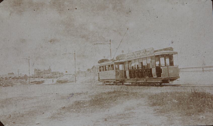 Faint photograph of double car electric tram.