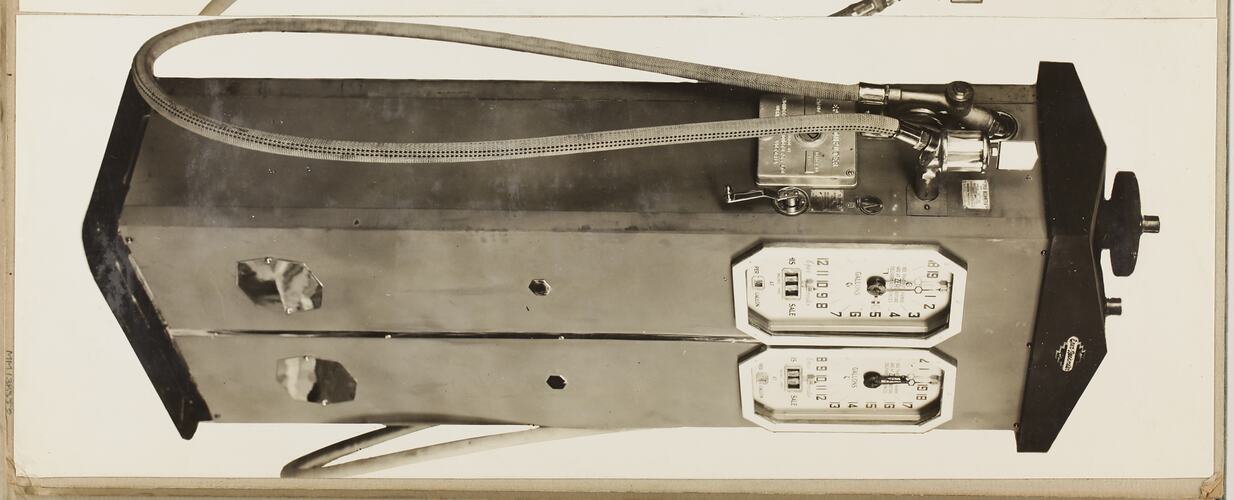 Monochrome photograph of an electric petrol pump.