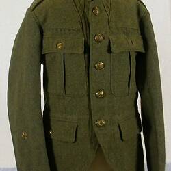 Khaki tunic with two hip pockets with button flaps. Two breast pockets with pleat and button flaps.
