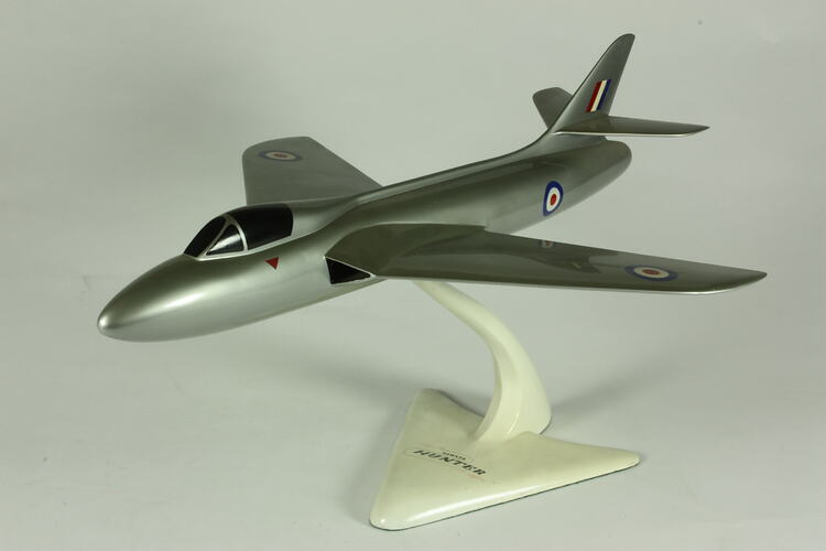 Silver model aeroplane on white stand.