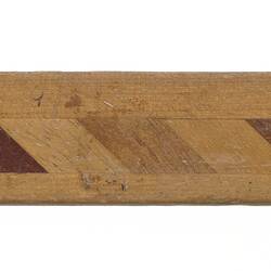 Wooden ruler with strips of different identified Australian timbers along length.
