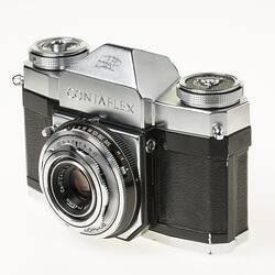 Black camera, metal lens and top section, dials in each corner. Front angle view.