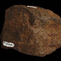 Rounded orange rock with hand written number.
