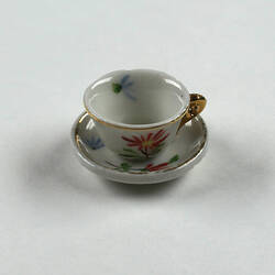 Side view of tiny tea cup and saucer.