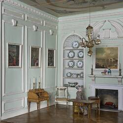 Doll's house interior room. Furnished and featuring costumed figure.