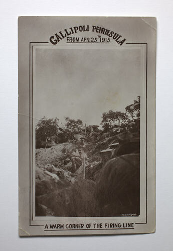 Trenches with seated soldiers on hillside.