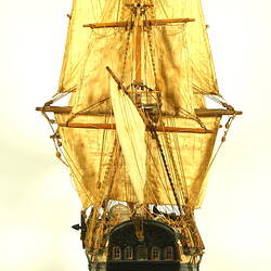 Wooden ship with three masts, rear view.